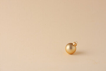 Christmas pastel beige minimal background with beige ball. Close up, copy space