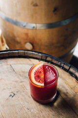 blood orange drink cocktail with ice on bourbon whiskey barrel 