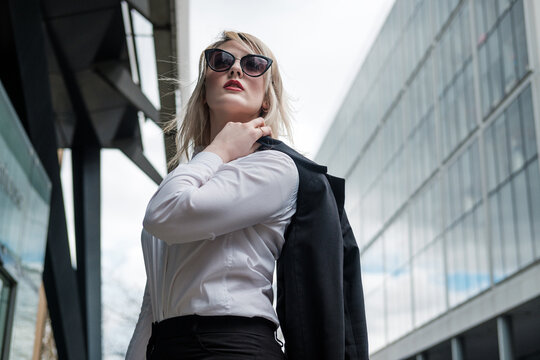 Portrait of a young business woman in the City of London wearing sunglasses.