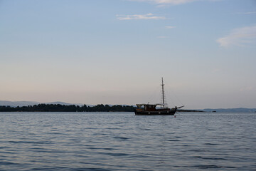 Photo of a boat sailing from the coast in the evening