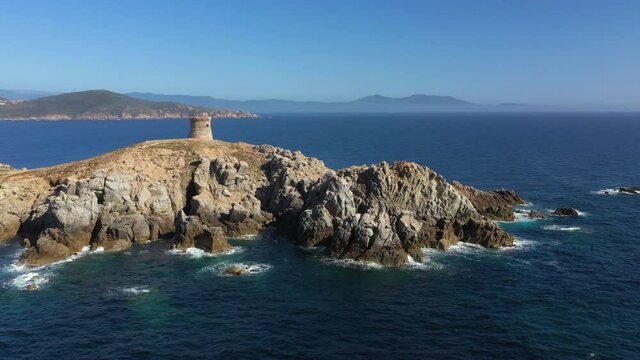 Vue a&eacute;rienne de la mer M&eacute;diterran&eacute;e et de la Tour g&eacute;noise d'Omigna au coucher du soleil, en Corse - 4K video, 25 fps. 