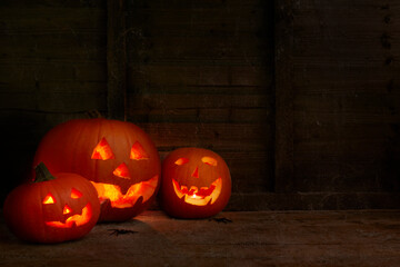 glowing pumpkins on a dark wooden cobweb background