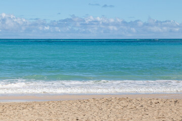 Fototapeta na wymiar Calm blue waves breaking gently on Waimānalo Beach, Oahu, Hawaii, USA