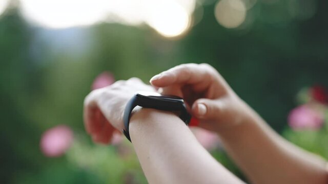 Smart watch on female wrist. Girl check pulse on fitness bracelet. Smartwatch. Young woman using smart watch. Female touching touch screen on watch entering watch app