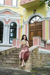 beautiful lady wear elegant cloth standing near a city building