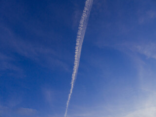 Smuga kondensacyjna na niebie, po przelocie samolotu. - obrazy, fototapety, plakaty