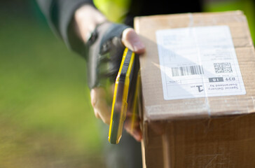 Close up courier with smart phone delivering package