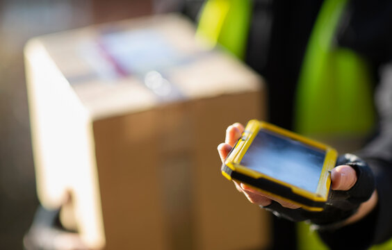 Close up courier with smart phone delivering package