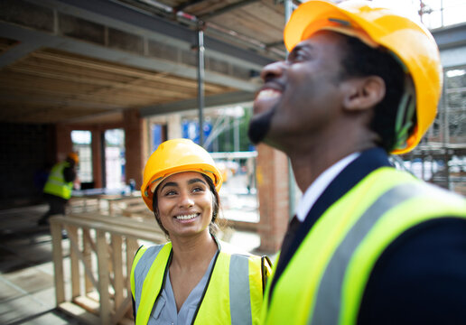 Happy Construction Workers Talking At Construction Site