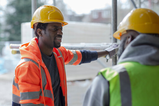 Male construction workers talking at construction site