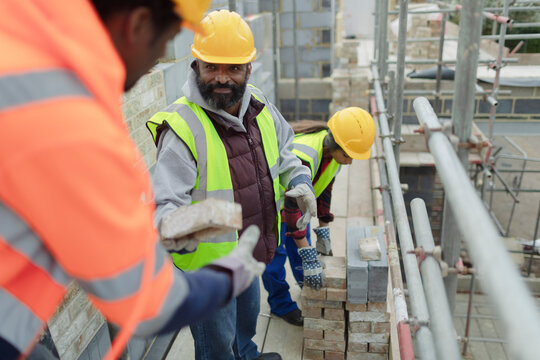 Construction workers laying brick at construction site
