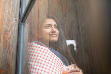 Thoughtful beautiful young woman looking out window