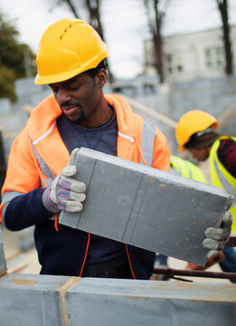 Male construction worker laying cement bricks