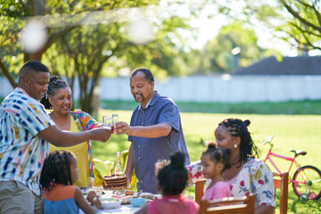 Multigenerational family celebrating birthday in summer backyard