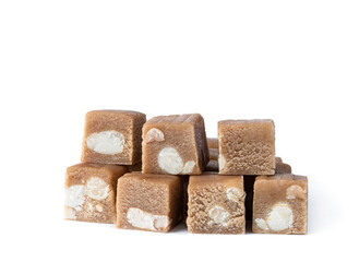 cubes of toffee fudge with monkey nuts isolated on white