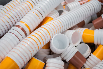 Many stacks of empty orange and brown plastic cups at warehouse, factory, plant - close up. Manufacturing, recycling, industry, technology concept