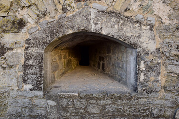 Fototapeta na wymiar An embrasure for shooting in the thick wall of an old fortress or castle