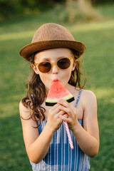 Mädchen isst Wassermelone am Stiel