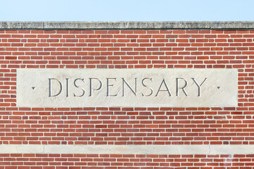 Stone dispensary sign on a brick building—marijuana and cannabis