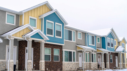 Pano Two storey houses with colorful walls in a neighborhood landscape with snow
