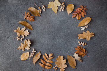 Obraz na płótnie Canvas Autumn floral greeting card made of dried leaves