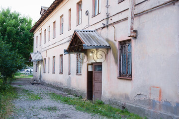 old house in the shadow of modern new buildings