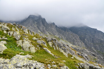 Fototapeta premium Scenic view Of landscape and rocky foggy mountains against cloudy sky in High Tatras, Slovakia
