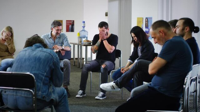 Male addict crying during group meeting