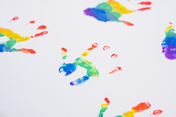 Child handprints of rainbow colors, on white sheet of paper