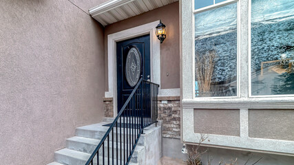 Pano Outdoor stairs with handrail and front door with oval glass pane at home facade