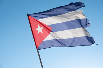 Cuban flag waving in wind. Flag of Cuba on blue sky background. Empty copy space.