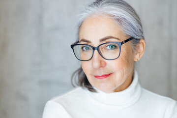 mature woman with glasses looking to the side. happy woman grand
