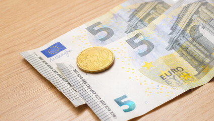 Euro banknotes and coin of twenty cent on a table. Closeup photo and top view. European Union economy, finance and business.