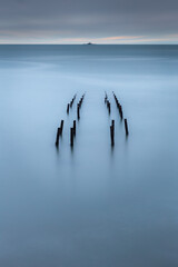 Long exposure image of an ancient pier pillars with space for text.