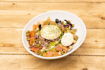 Great Mediterranean salad with lots of seasonings. Laminated boiled egg, canned tuna, goat cheese, pieces of green olives, cooked chickpeas, chopped tomatoes, lettuce and red onion.