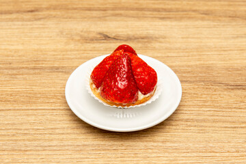 delicious tartlet with chopped strawberries and drizzled with syrup