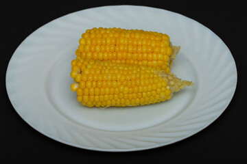 Cooked boiled corn on a white plate