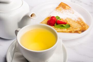 Breakfast with green tea and strawberry pancake.