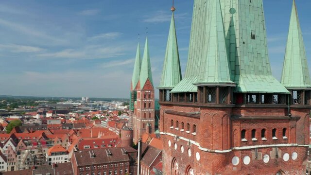 Fly around lookout terrace at St. Peters church brick tower. Aerial view of medieval town centre with St. Marys church. Luebeck, Schleswig-Holstein, Germany