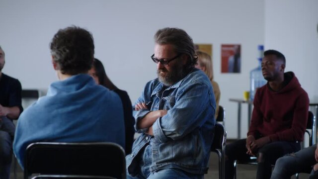 Upset middle aged man talking about alcohol addiction during AA meeting