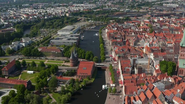 Tilt up a pan reveal of city. Historic red brick buildings in old town separated by river from other neighbourhoods. Luebeck, Schleswig-Holstein, Germany