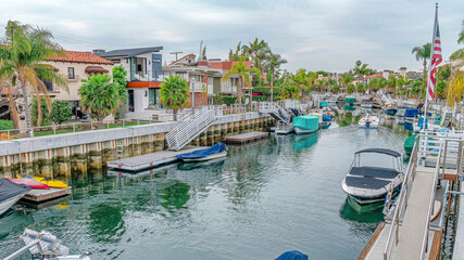 Fototapeta na wymiar Pano Homes lining the canal with boats in charming Long Beach California neighborhood