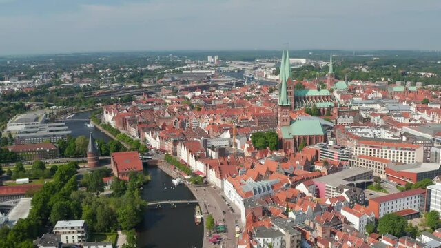 Backwards reveal of city. Aerial view of historic part of town with landmarks in UNESCO world heritage site. Luebeck, Schleswig-Holstein, Germany
