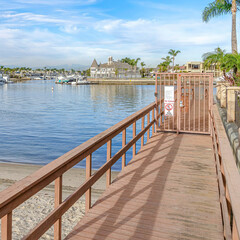 Square Boat docks in Huntington Beach California with sea and cloudy blue sky views