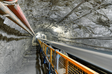 Underground belt conveyor for transporting ore to the surface