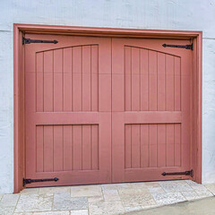 Square Brown wooden garage doors viewed at the facade of home in San Diego California