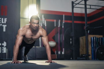 Fototapeta na wymiar Asian big muscular man Bodybuilder exercising to build muscle in gym.