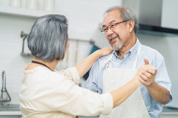 Asian romance senior elderly couple stay at home enjoy cook in kitchen.