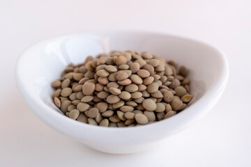 plato blanco con montón de lentejas crudas