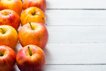 apple fruits in a row, white wooden table background